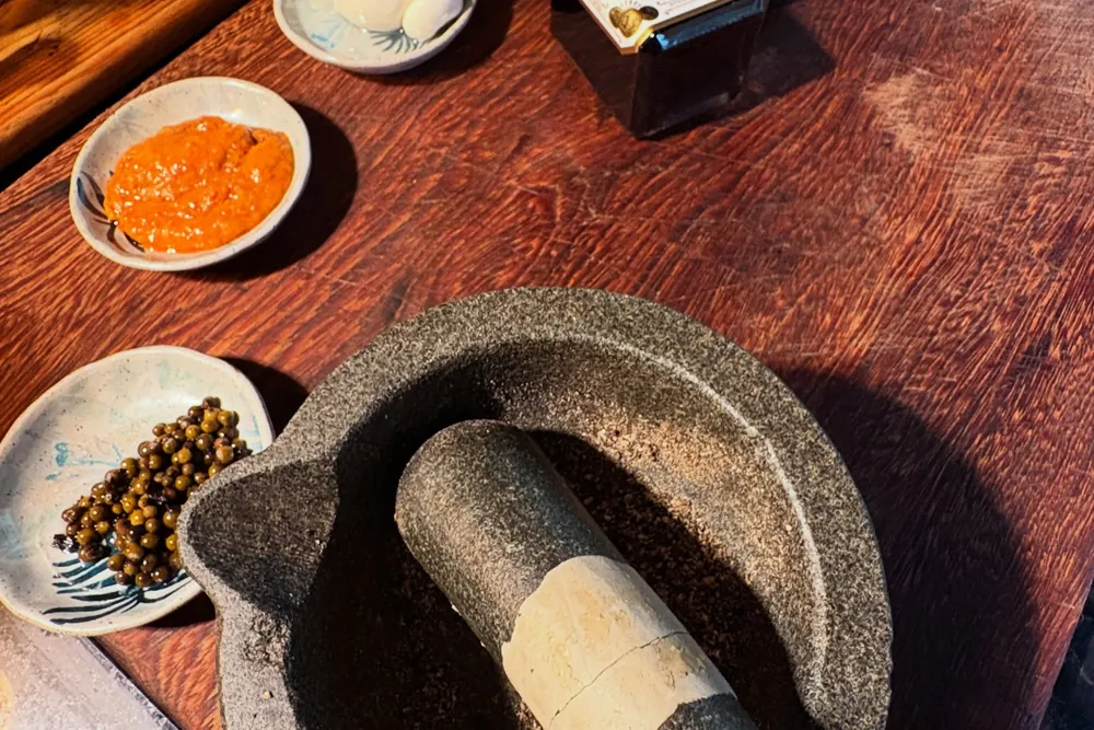 Pilão de pedra e temperos na bancada